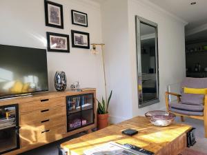 a living room with a television and a coffee table at Cocoa River - Quiet city centre, close to the Shambles, on the river, two bed, two bath, allocated parking in York +19 photos