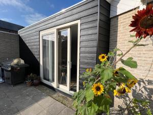 una puerta corredera de cristal en una casa con girasoles en Studio Donna en Vrouwenpolder