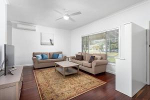 een woonkamer met twee banken en een tv bij 100 Paces in Broadwater