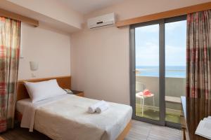 a bedroom with a bed and a view of the ocean at Nafsika Hotel in Rhodes Town