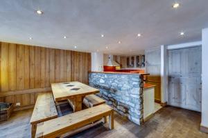 a kitchen with a counter and a table and a bar at BONNE NEIGE in La Daille