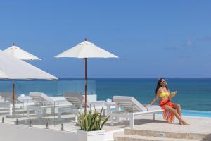 uma mulher sentada numa cadeira na praia em HM Bavaro Beach - Adults Only em Punta Cana