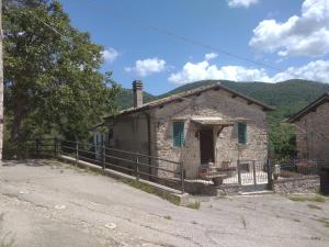 una vieja casa de piedra al lado de una carretera en Casa vacanze Borgo medievale, en Porzano