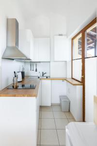a kitchen with white cabinets and a window at Todorka Apartments in Bansko in Bansko