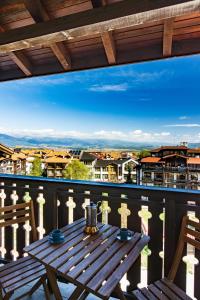 a table on a balcony with a view of a city at Todorka Apartments in Bansko in Bansko