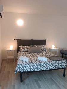 łóżko w pokoju z dwoma stołami i dwoma lampami w obiekcie Velia's Home Casa Vacanze B&b w mieście Castel SantʼElia