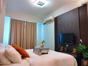 um quarto com uma cama grande e uma televisão em kinta river suite ipoh town 12 guest em Ipoh