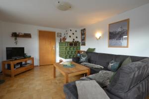 - un salon avec un canapé et une table dans l'établissement "Beim Brugger", à Lechbruck am See