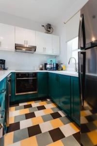 a kitchen with green cabinets and a checkered floor at Casa Love 1D - Precioso apartamento de 2Hab con balcón en Casco Antiguo in Panama City