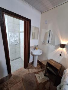 a bathroom with a white sink and a shower at Pousada da Fonte in Lençóis