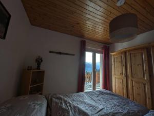 een slaapkamer met een bed en een groot raam bij Chalet Cactus - 4 Vallées in Hérémence