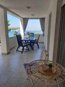 a dining room with a table and chairs and a view of the ocean at Varaždinci in Rogoznica