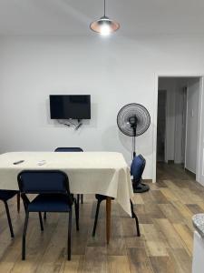 een eetkamer met een tafel en stoelen en een flatscreen-tv bij Departamento en Bragado B in Bragado