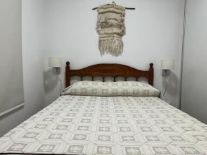 een bed in een slaapkamer met 2 lampen aan de muur bij Departamento en Bragado B in Bragado