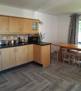 a kitchen with wooden cabinets and a wooden table at Finner-House in Bundoran