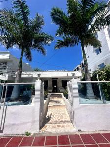 two palm trees in front of a house at Hotel Cartagena Airport in Cartagena de Indias