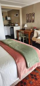 Una sala de estar con una cama y una cocina. en Die Huisies, en East London 19 fotos más