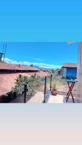 a view from the balcony of a house with a table at buganvile hostel in Abraão