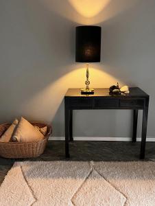 a table with a lamp on it with a basket at Sea view nordic design apartment near beach great for couples in Snekkersten