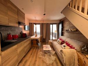 un soggiorno con divano e una cucina di La Marmotte Duplex 4 p. entièrement rénové avec vue magnifique a Monginevro