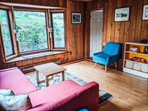 ein Wohnzimmer mit einem Sofa und einem blauen Stuhl in der Unterkunft Nettledown Farms Bed & Breakfast in Salt Spring Island