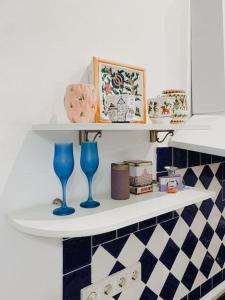 a white shelf with two blue glasses on it at ART Apartments in Lviv