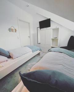 1 Schlafzimmer mit 2 Betten und einem Flachbild-TV in der Unterkunft Ferienwohnung Watt un Leev in direkter Strand & Citynähe von Büsum in Büsum