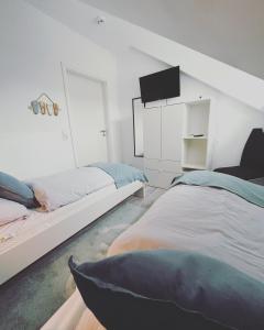 una camera da letto con due letti e una TV a schermo piatto di Ferienwohnung Watt un Leev in direkter Strand & Citynähe von Büsum a Büsum