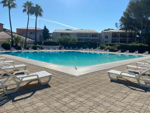 uma grande piscina com espreguiçadeiras num resort em Domaine Valescure Appartement 1 ou 2 pieces vue jardin ou piscine em Saint-Raphaël