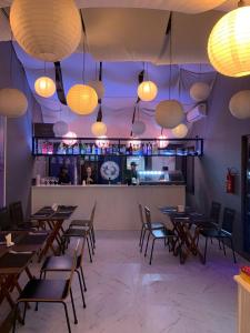 a dining room with tables and chairs and lights at Nômades Club House in Balneário Camboriú