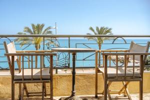 a table and chairs on a balcony overlooking the beach at Hôtel du Bord de Mer "Le Vanillé" in Cagnes-sur-Mer