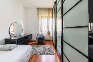 1 dormitorio con cama y espejo en PARKING & WIFI City Walls Apartment en Pistoia