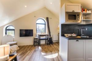 a kitchen and living room with a table at Beau L.O.F.T. sous les toits - vue sur mer 2 à 4 personnes - Résidence la Vague in Houlgate