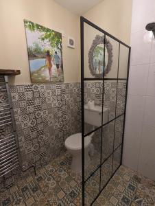 a bathroom with a toilet and a picture on the wall at Bluebell Cottage in Armagh