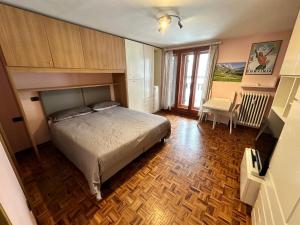 - une chambre avec un lit et une chaise dans l'établissement Appartamento Centro Breuil CIR 0139-0142, à Breuil-Cervinia
