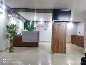 um quarto com uma televisão na parede e uma secretária em Hotel Mahadev Rishikesh em Rishikesh