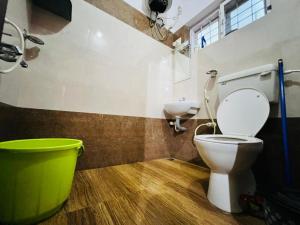 La salle de bains est pourvue de toilettes et d'une baignoire verte. dans l'établissement Paddy View Service Villa, à Wayanad
