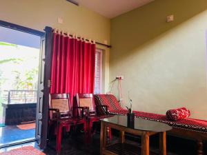 - un salon avec un canapé, des chaises et une table dans l'établissement Paddy View Service Villa, à Wayanad