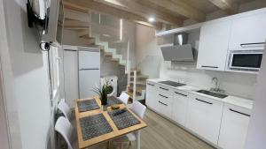 a kitchen with white cabinets and a small table in it at APARTAMENTOS AREKORATAS 255 y 256 