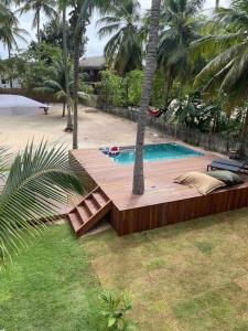 AmontadaにあるVila dos Cocos - Praia de Moitasのヤシの木の横に木製デッキ付きのプール +22枚の写真