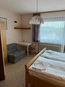 1 dormitorio con 1 cama, 1 mesa y 1 silla en Doppelzimmer Nr. 1, en Freiensteinau