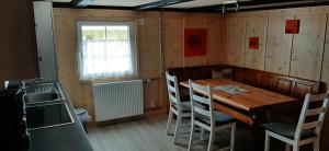 una sala da pranzo con tavolo e sedie in legno di Familien Ferienwohnung Linder a Grafenhausen