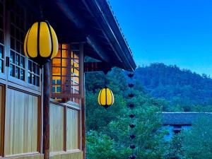 two yellow lanterns hanging from the side of a building at Wudang Mountain Manju Manor in Wudangshan