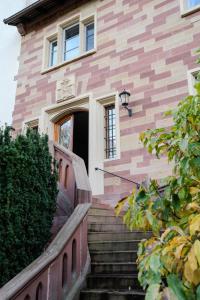 a house with stairs leading up to a door at Eventlocation & Hotel Schloss Neuburg in Obrigheim