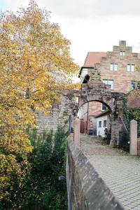 um velho edifício de tijolos com um arco em frente em Eventlocation & Hotel Schloss Neuburg em Obrigheim