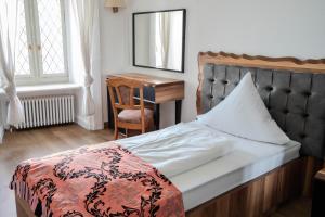 a bedroom with a bed and a desk and a mirror at Eventlocation & Hotel Schloss Neuburg in Obrigheim