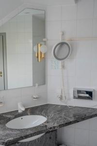 a bathroom with a sink and a mirror and a phone at Eventlocation & Hotel Schloss Neuburg in Obrigheim