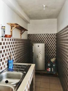 a kitchen with a sink and a refrigerator in it at 2 chambres dans un appartement avec vue sur la mer in Cotonou