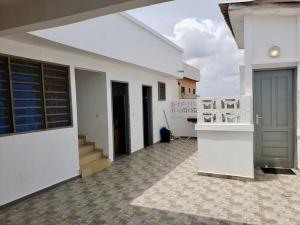 a white house with a hallway with a door at 2 chambres dans un appartement avec vue sur la mer in Cotonou