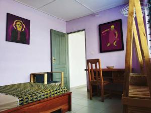 a bedroom with a bed and a desk and a chair at 2 chambres dans un appartement avec vue sur la mer in Cotonou